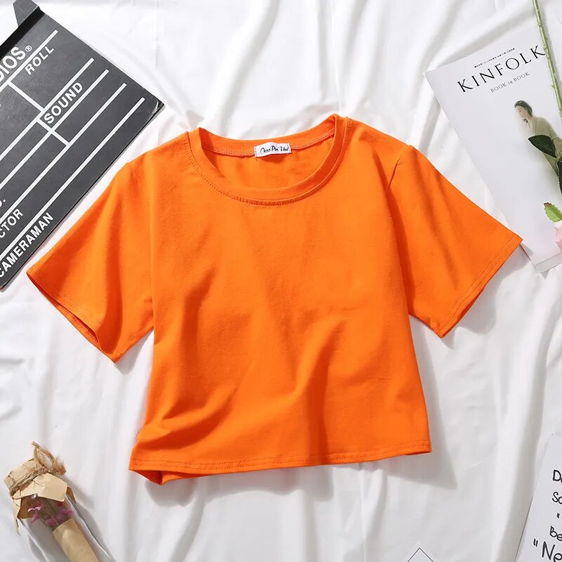 Vibrant orange Femzai Solid Crop Tee, adding a pop of color to femboy clothes, highlighted against a pristine white backdrop