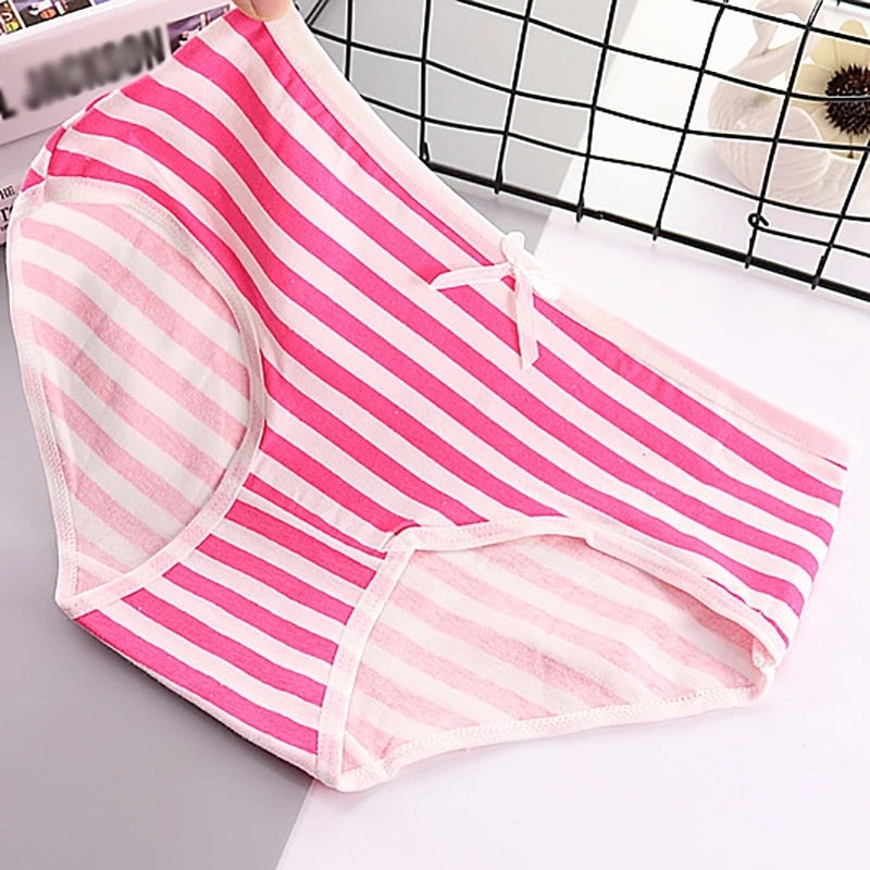 A single pink and white striped panty with a prominent white bow is highlighted in this shot. The angle provides a clear view of the item's pattern and texture, which aligns with femboy clothing styles.