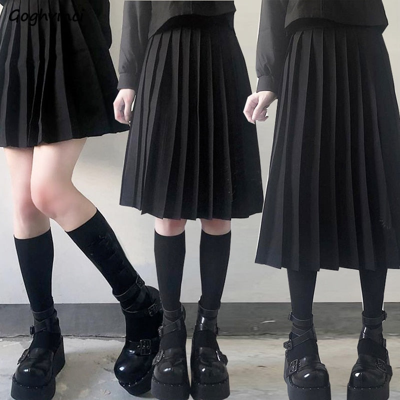 A collage of four images showcasing a person in a long black pleated skirt paired with black knee-high socks and chunky black shoes. Each shot captures a different angle of the femboy clothing style, ranging from frontal to side views.