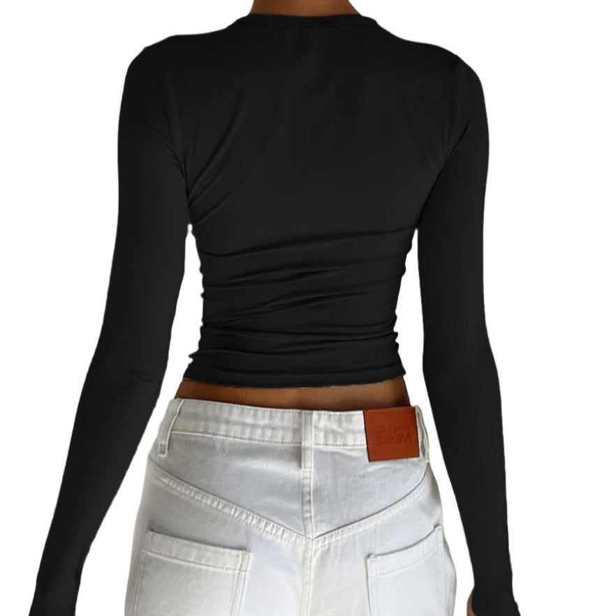 Medium shot rear view of a model showcasing a black Femzai long-sleeve ruched top paired with high-waisted white jeans featuring a leather belt and buckle details, perfect for femboy streetwear