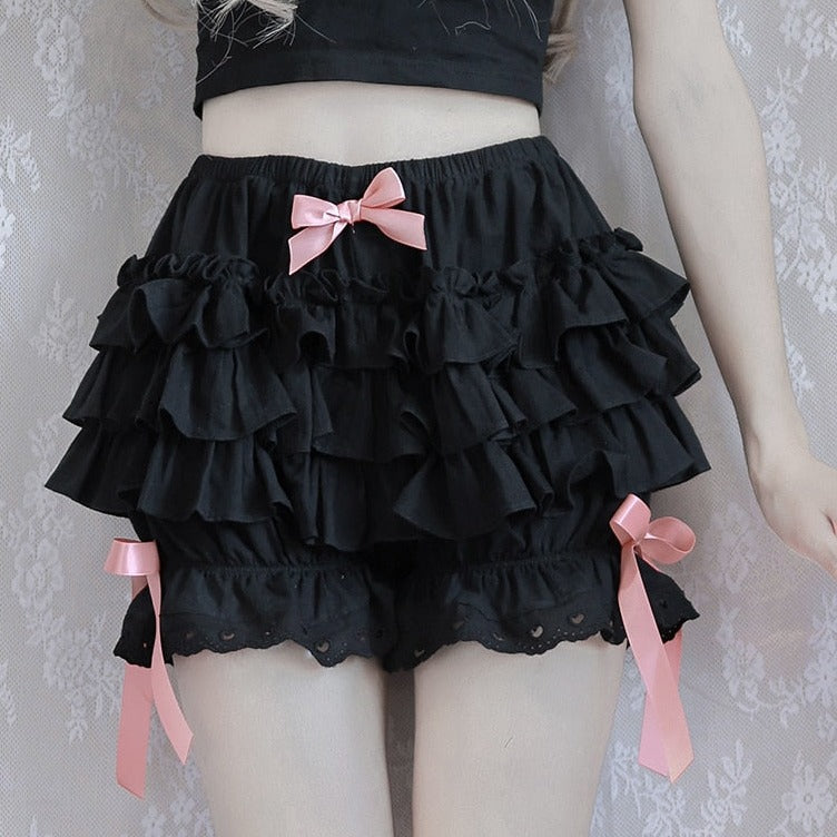 Front view of a model in a black bow ruffle skirt, an essential femboy clothing staple.