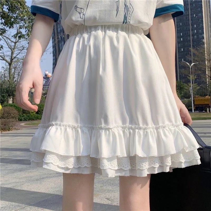 White Femzai Lace Pleated Ruffle Skirt, viewed from the waist down, highlighting its sophisticated lace and pleated features, a chic option for femboy attire.