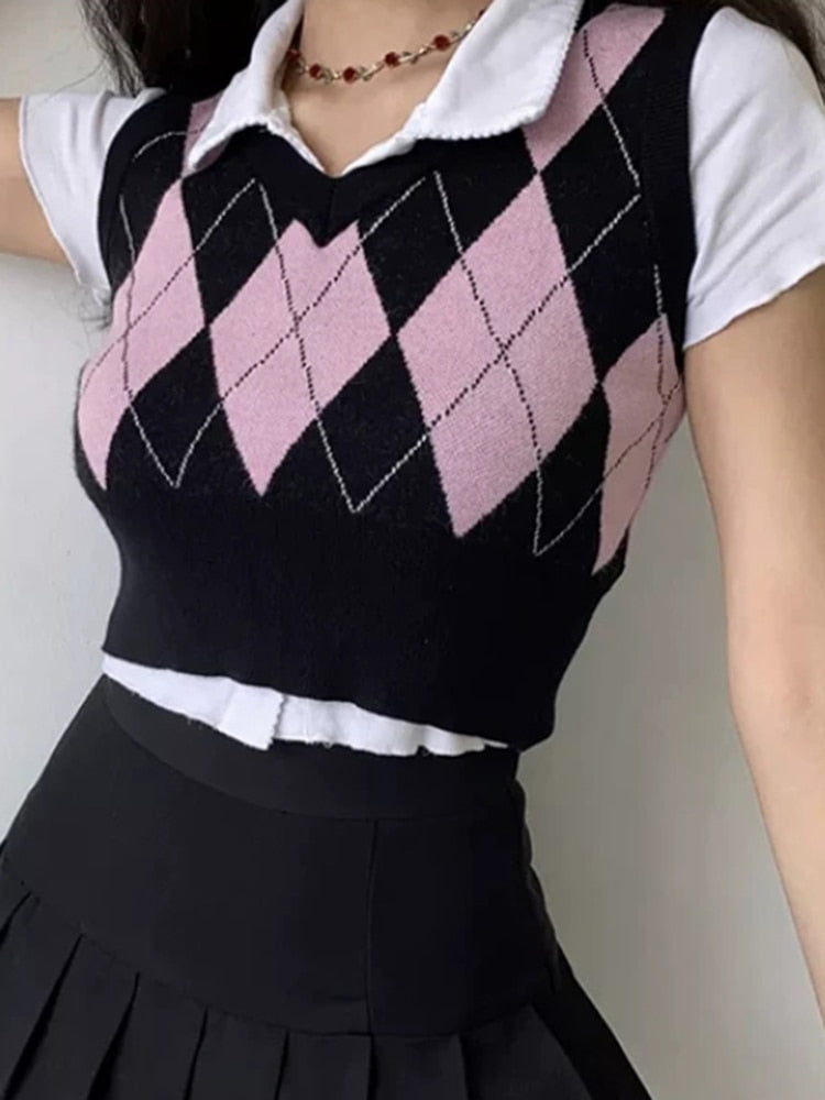 Close-up shot front view of a model showcasing a black and pink Femzai Gridded V-neck Vest with a white collar, complemented by a black pleated skirt and a delicate gold necklace, epitomizing chic feminine style.