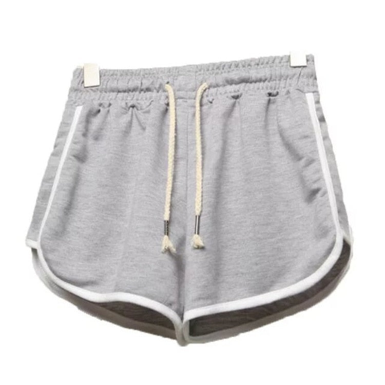 Close-up shot of light gray dolphin shorts with white trim, front view, showcasing drawstrings and a tag detail. Key product for femboy clothing in a laid-back style.